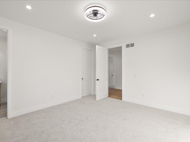 unfurnished room featuring light colored carpet