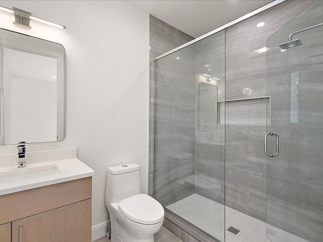 bathroom featuring vanity, toilet, and a shower with door