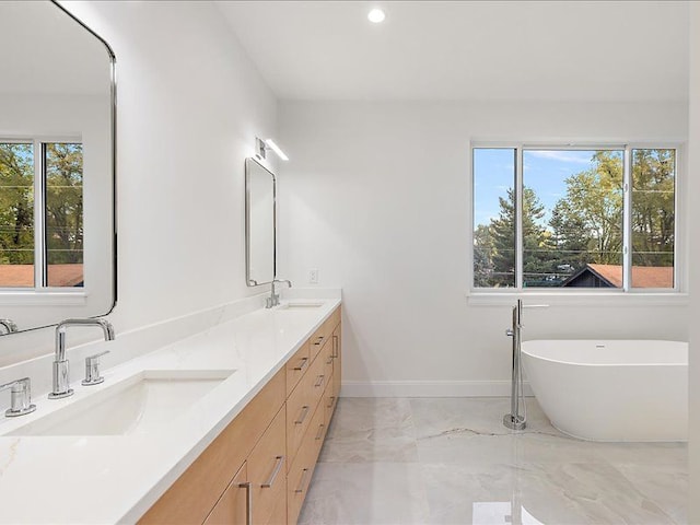 bathroom featuring a washtub and vanity