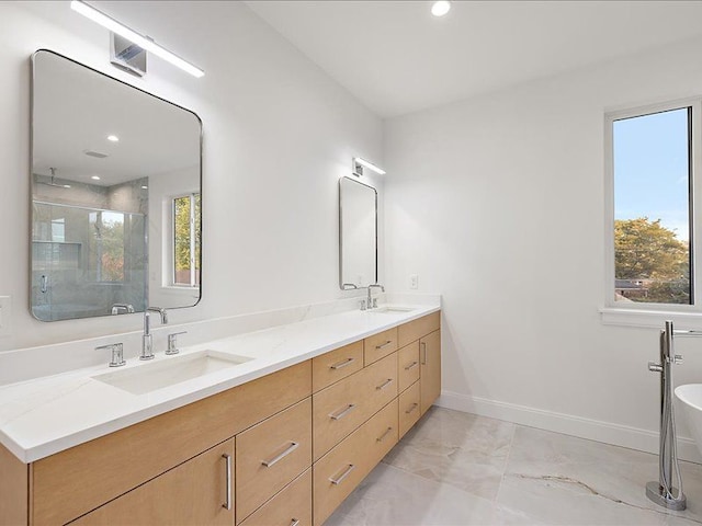 bathroom with vanity, a healthy amount of sunlight, and walk in shower