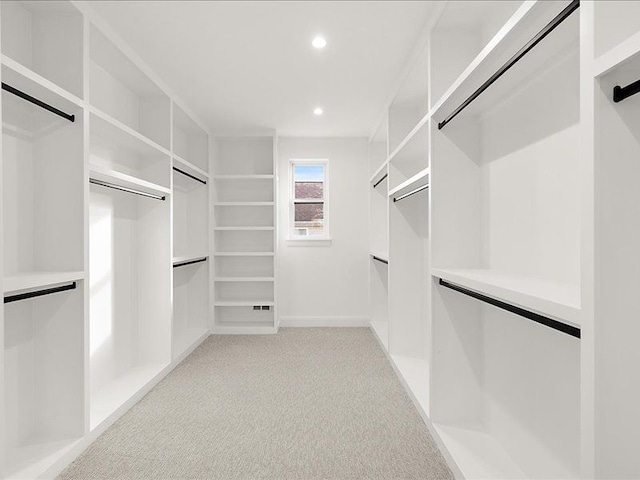 walk in closet with light colored carpet