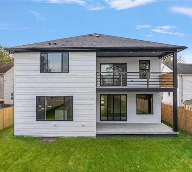 back of house with a yard, a balcony, and a patio