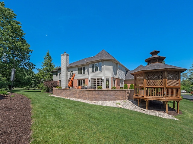 rear view of house with a gazebo and a yard