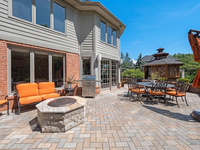 view of patio / terrace featuring a gazebo, a fire pit, and a grill