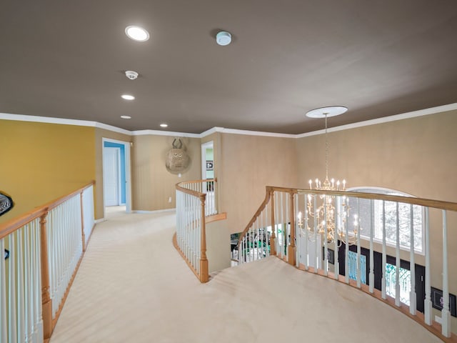 hall featuring a notable chandelier, light colored carpet, and crown molding