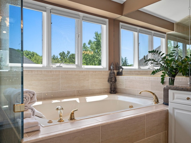 bathroom with vanity and tiled bath