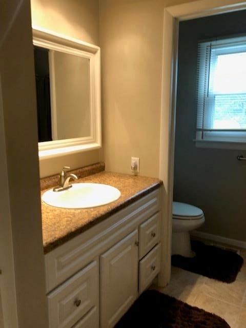 bathroom featuring tile patterned floors, vanity, and toilet