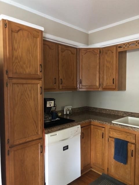 kitchen featuring crown molding, white dishwasher, and dark wood-type flooring