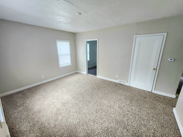 unfurnished bedroom featuring carpet and a textured ceiling