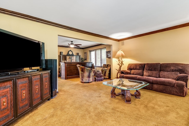 carpeted living room with ceiling fan and crown molding