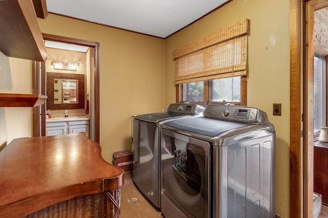 laundry area with crown molding, separate washer and dryer, and sink