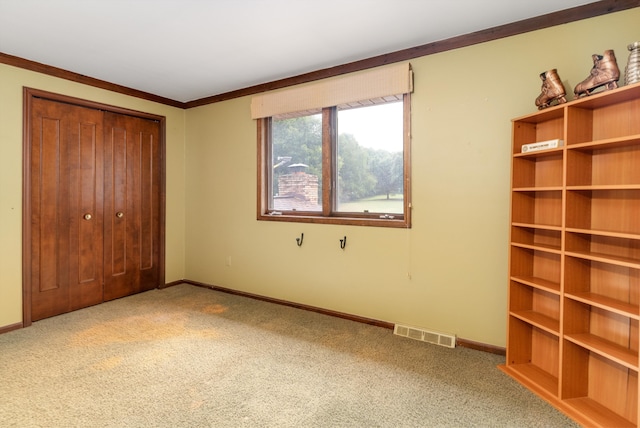 unfurnished bedroom featuring a closet, carpet floors, and ornamental molding