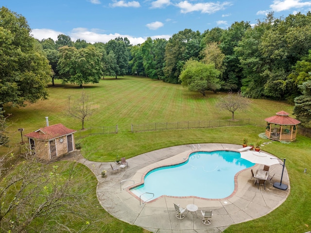 view of pool with a rural view, a yard, a gazebo, a patio, and an outbuilding