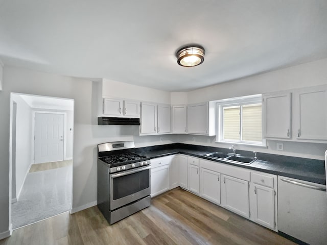 kitchen with sink, stainless steel gas stove, white cabinets, and light wood-type flooring