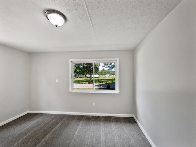 carpeted empty room featuring a textured ceiling