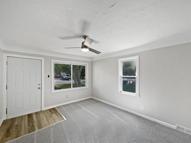 carpeted spare room featuring ceiling fan