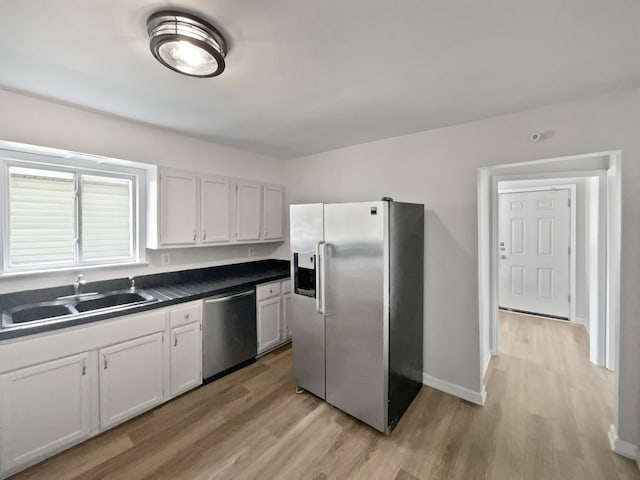 kitchen featuring white cabinetry, sink, appliances with stainless steel finishes, and light hardwood / wood-style flooring