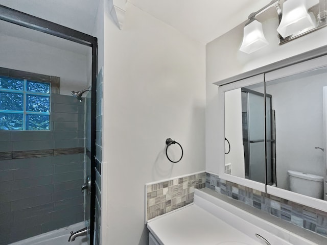 bathroom with vanity, tasteful backsplash, and toilet