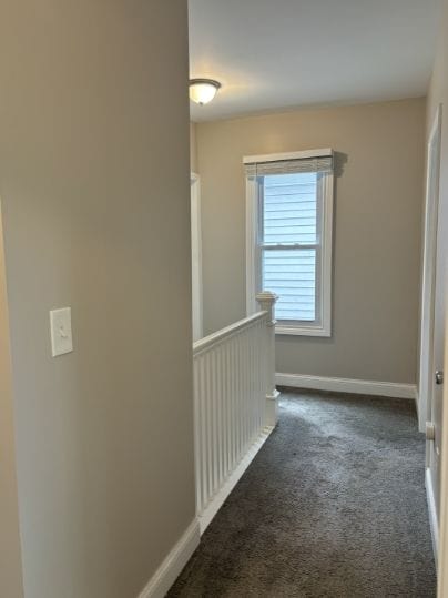 corridor with dark colored carpet