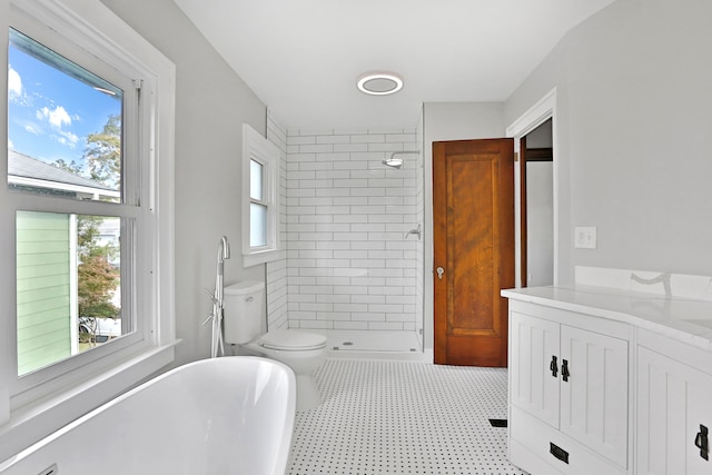 bathroom with a tile shower, vanity, and toilet