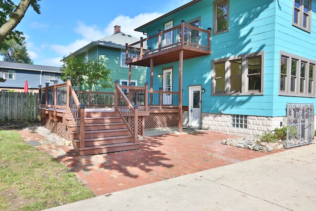 back of house with a balcony and a deck