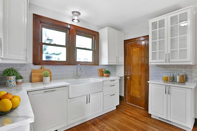 kitchen with white cabinetry, sink, light stone counters, wood-type flooring, and decorative backsplash