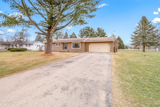 ranch-style home with a garage and a front lawn