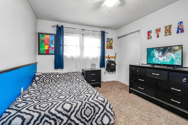 bedroom featuring ceiling fan, a closet, a baseboard radiator, and carpet