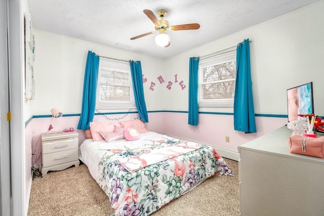 bedroom with light colored carpet, a textured ceiling, and ceiling fan