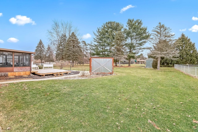 view of yard featuring a deck and a storage unit