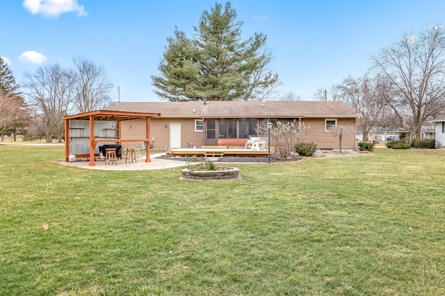 rear view of house with a wooden deck, a yard, a patio area, and a sunroom