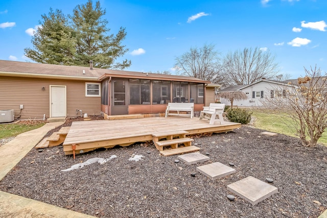 rear view of property featuring a wooden deck, a sunroom, and central AC