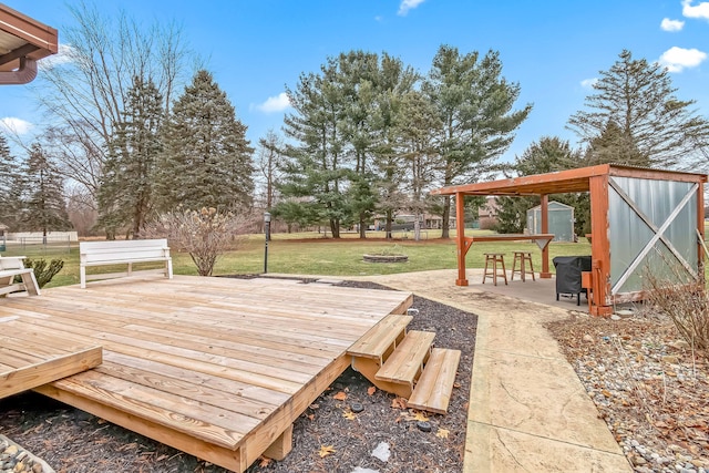 deck with a patio, a yard, and a storage shed