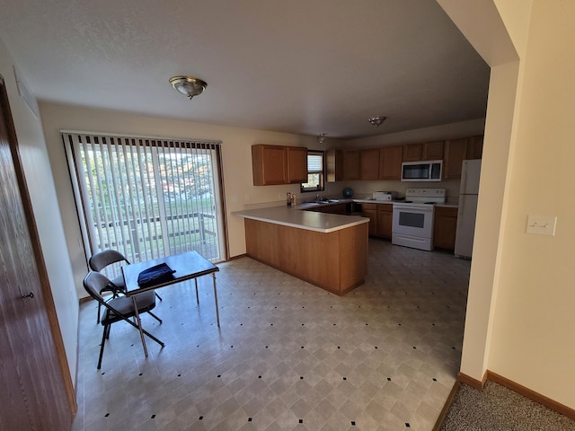 kitchen featuring sink, white appliances, and kitchen peninsula