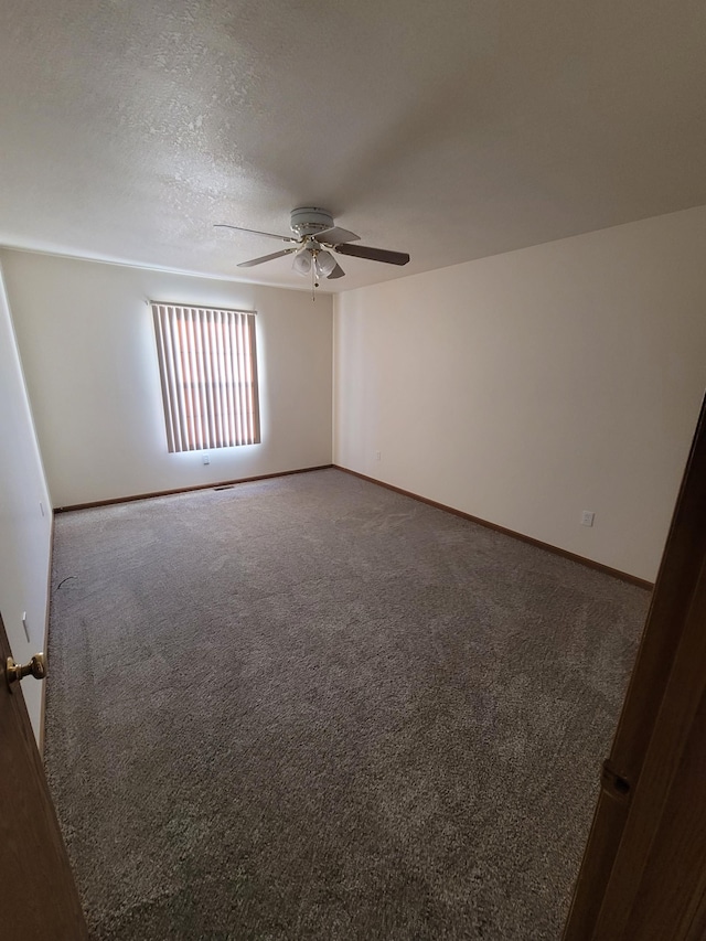 carpeted spare room featuring ceiling fan and a textured ceiling