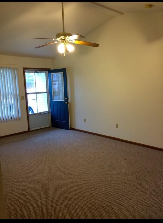 empty room featuring ceiling fan, carpet, and vaulted ceiling