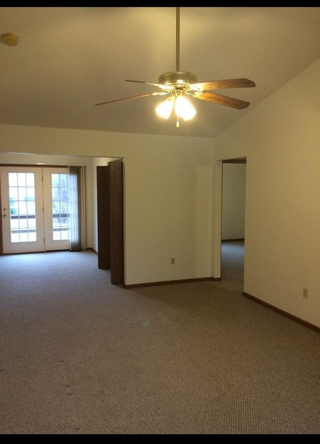 empty room with french doors, carpet floors, vaulted ceiling, and ceiling fan