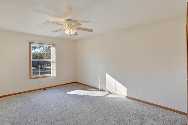 carpeted spare room with ceiling fan and a textured ceiling