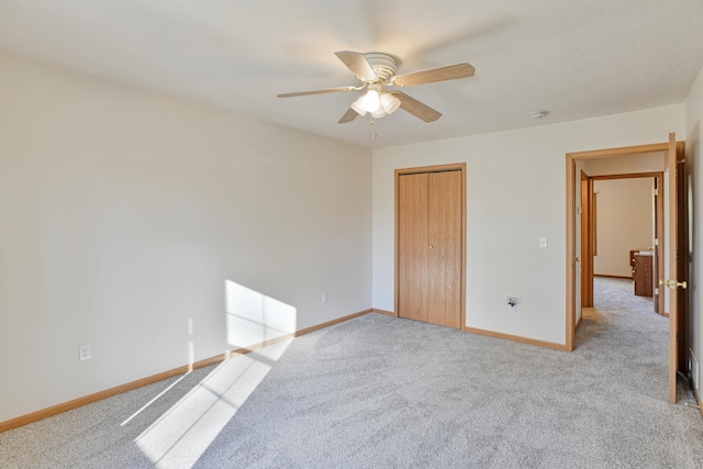 unfurnished bedroom featuring light carpet, a closet, and ceiling fan