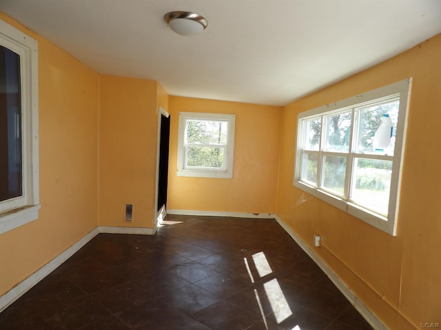 unfurnished room with dark tile patterned flooring