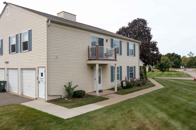 view of front of home with a balcony, a front yard, and a garage