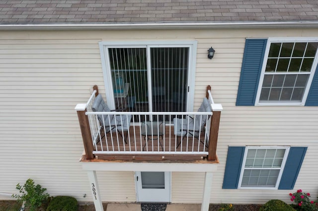 view of exterior entry with a balcony