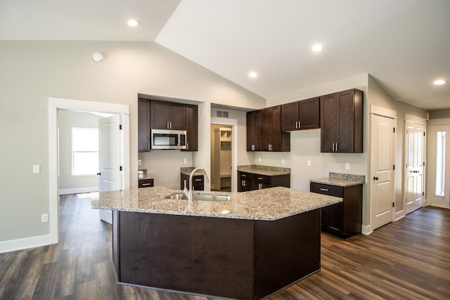 kitchen with lofted ceiling, sink, an island with sink, dark brown cabinets, and dark hardwood / wood-style flooring