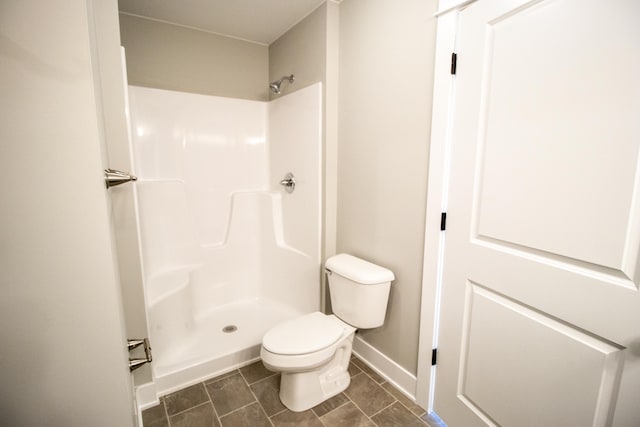 bathroom featuring tile patterned floors, toilet, and walk in shower