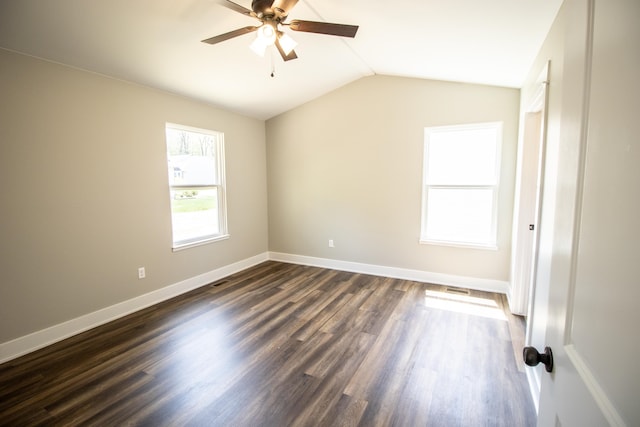 spare room with vaulted ceiling, ceiling fan, and dark wood-type flooring