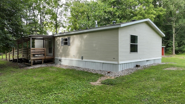 view of side of property featuring a lawn and a wooden deck