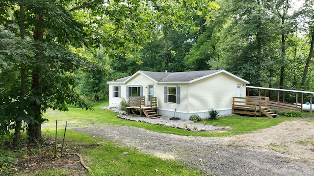 view of front of property with a wooden deck and a front lawn