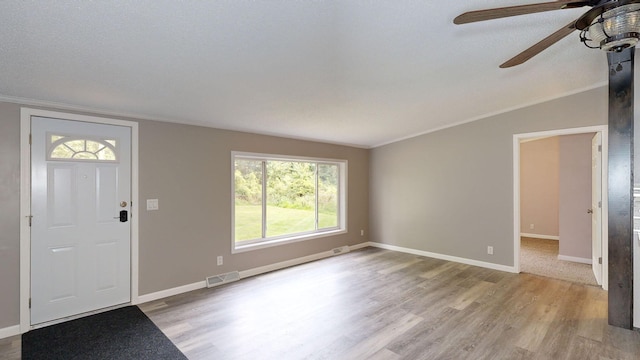 entrance foyer featuring a textured ceiling, light hardwood / wood-style flooring, ceiling fan, and lofted ceiling