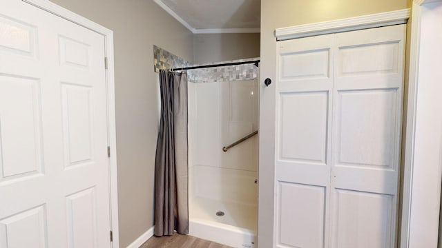 bathroom with hardwood / wood-style floors, curtained shower, and crown molding