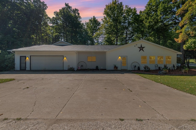 6610 E Arnold Lake Rd, Harrison, MI 48625 - view of front of property with driveway, a garage, and view of wooded area